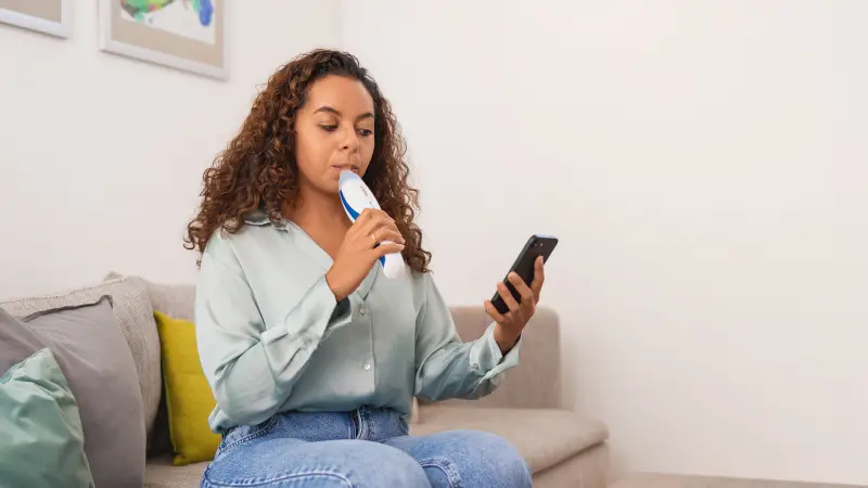 Patientin misst ihren FeNO-Wert mithilfe der Echtzeit-Visualisierung