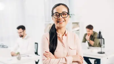 Helpful-looking woman in the service area with colleagues in the background